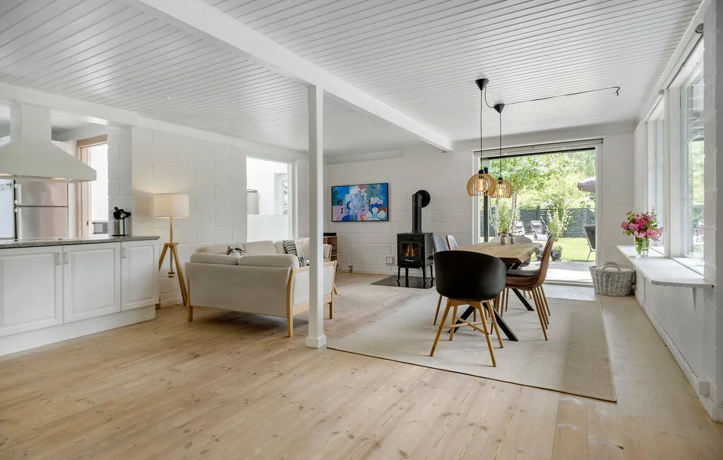 An open-plan living and dining area connects to a bright kitchen, with garden views.