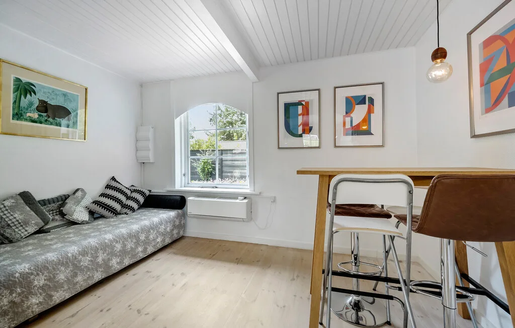 A bright living area with seating, a window, and a dining table.