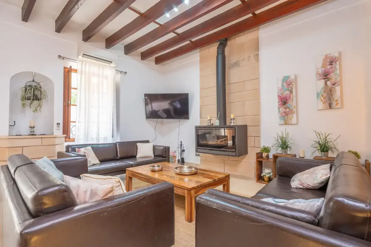 A living room with leather seating, a wooden coffee table, and a fireplace.