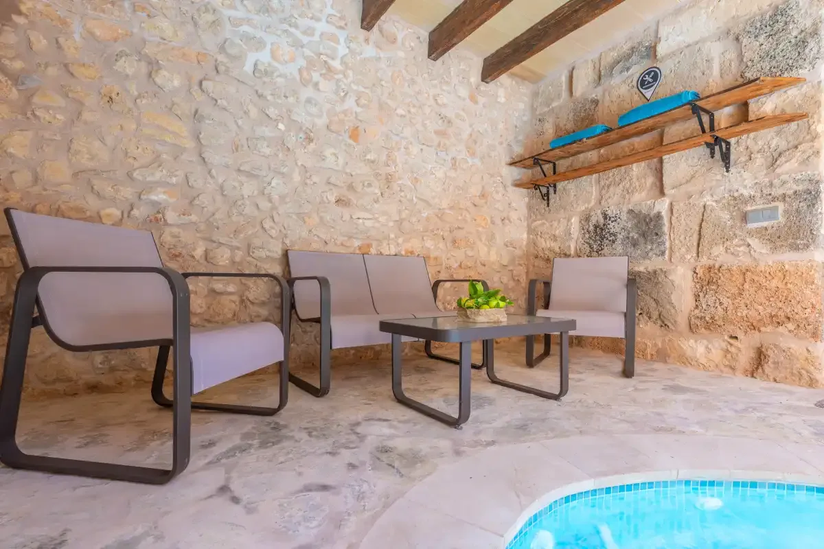 A stone-walled seating area with chairs and a low table.