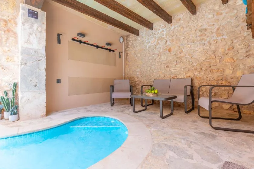 A small indoor pool beside a stone-walled seating area.