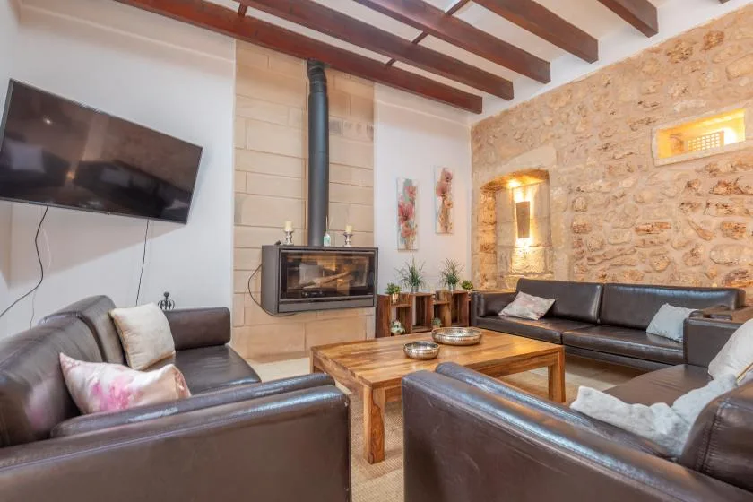 A living room with leather seating, a wooden coffee table, and a wall-mounted television.