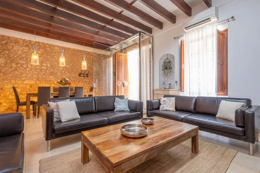 A living room with dark seating around a wooden coffee table.