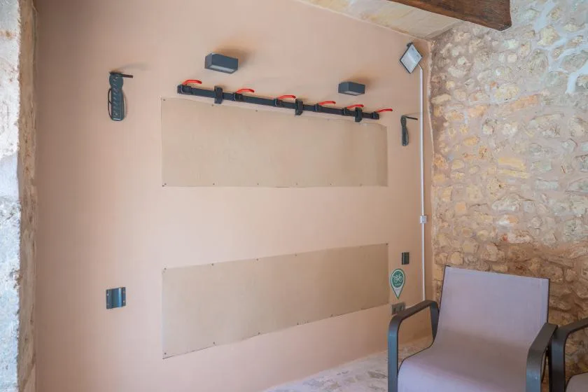 A seating area with a wall-mounted rack and a stone wall.