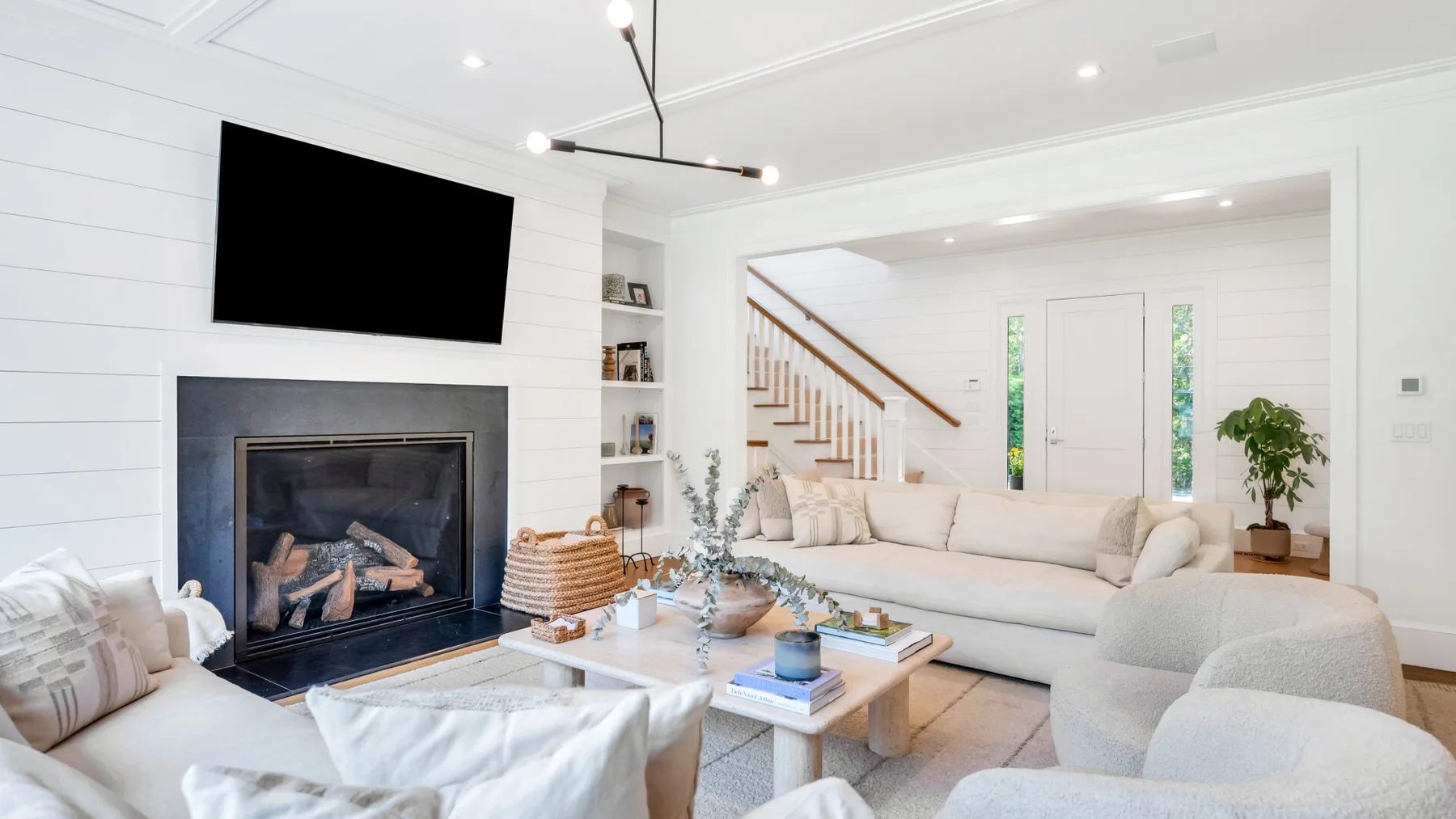 Una sala luminosa con asientos claros y una chimenea.