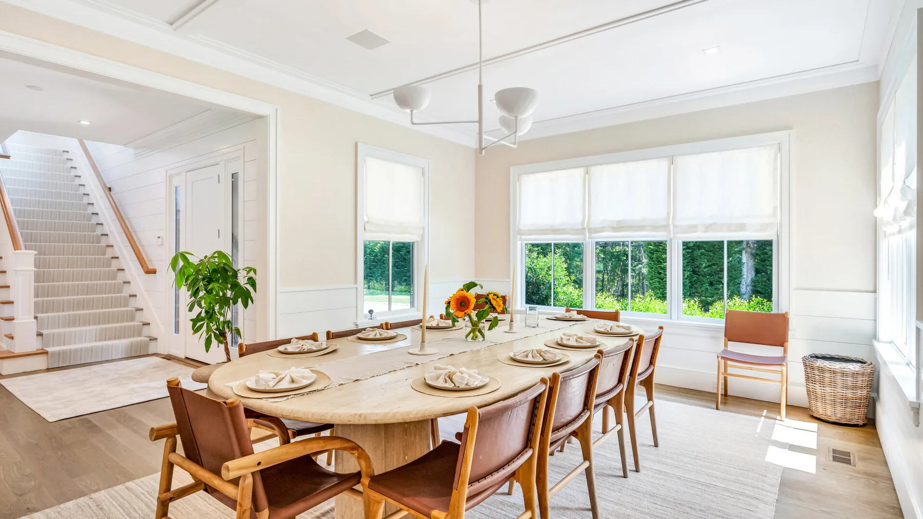 Un comedor luminoso con una mesa larga y ventanas amplias.