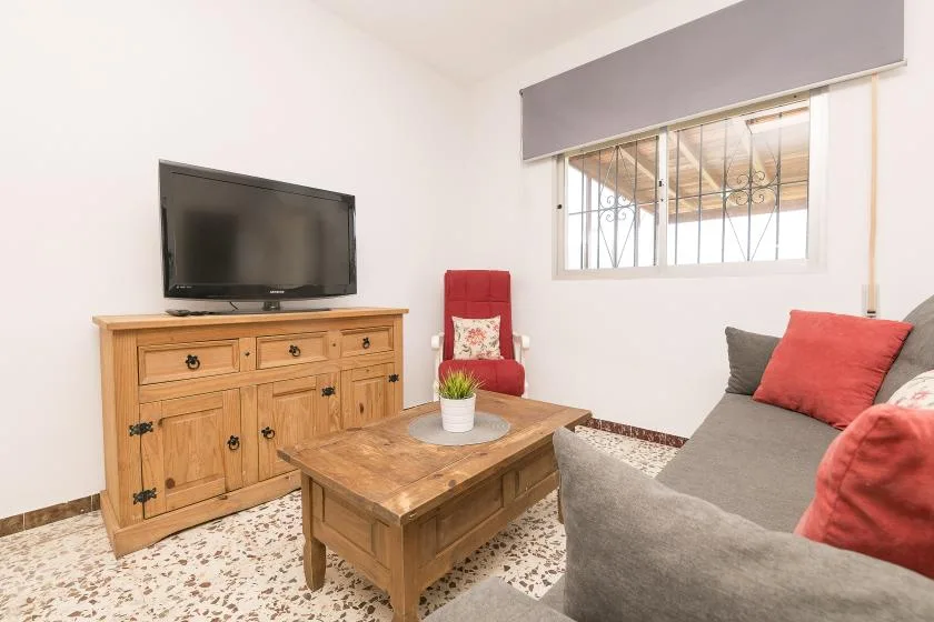 A living room with a television, wooden coffee table, and seating.
