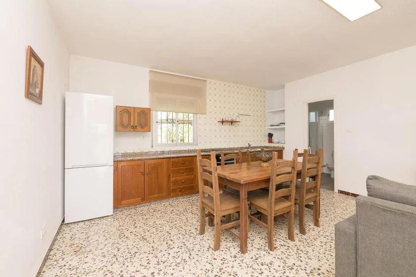 A dining area with a wooden table and chairs beside the kitchen.