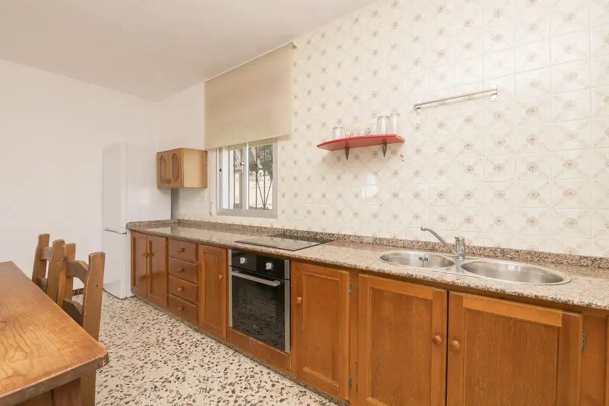 A kitchen with wooden cabinets, a countertop, and a sink.