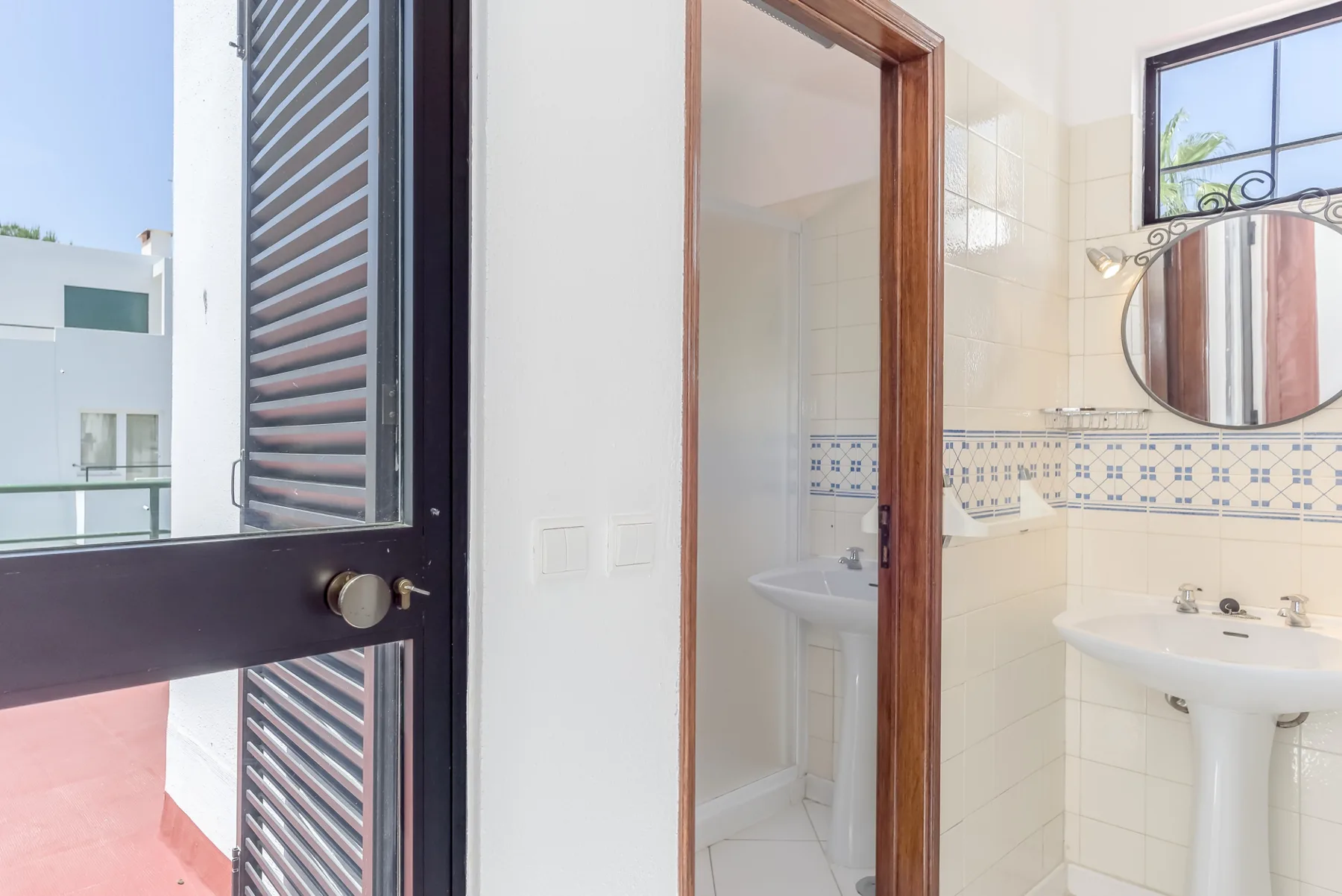 A tiled bathroom with a sink and an open doorway.