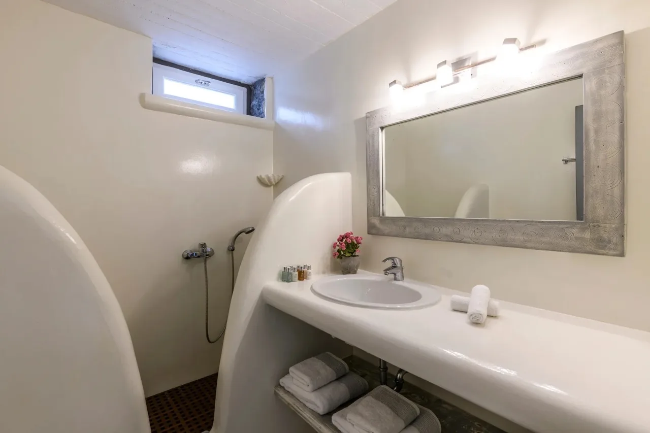 A bathroom with a sink, large mirror, and shower.