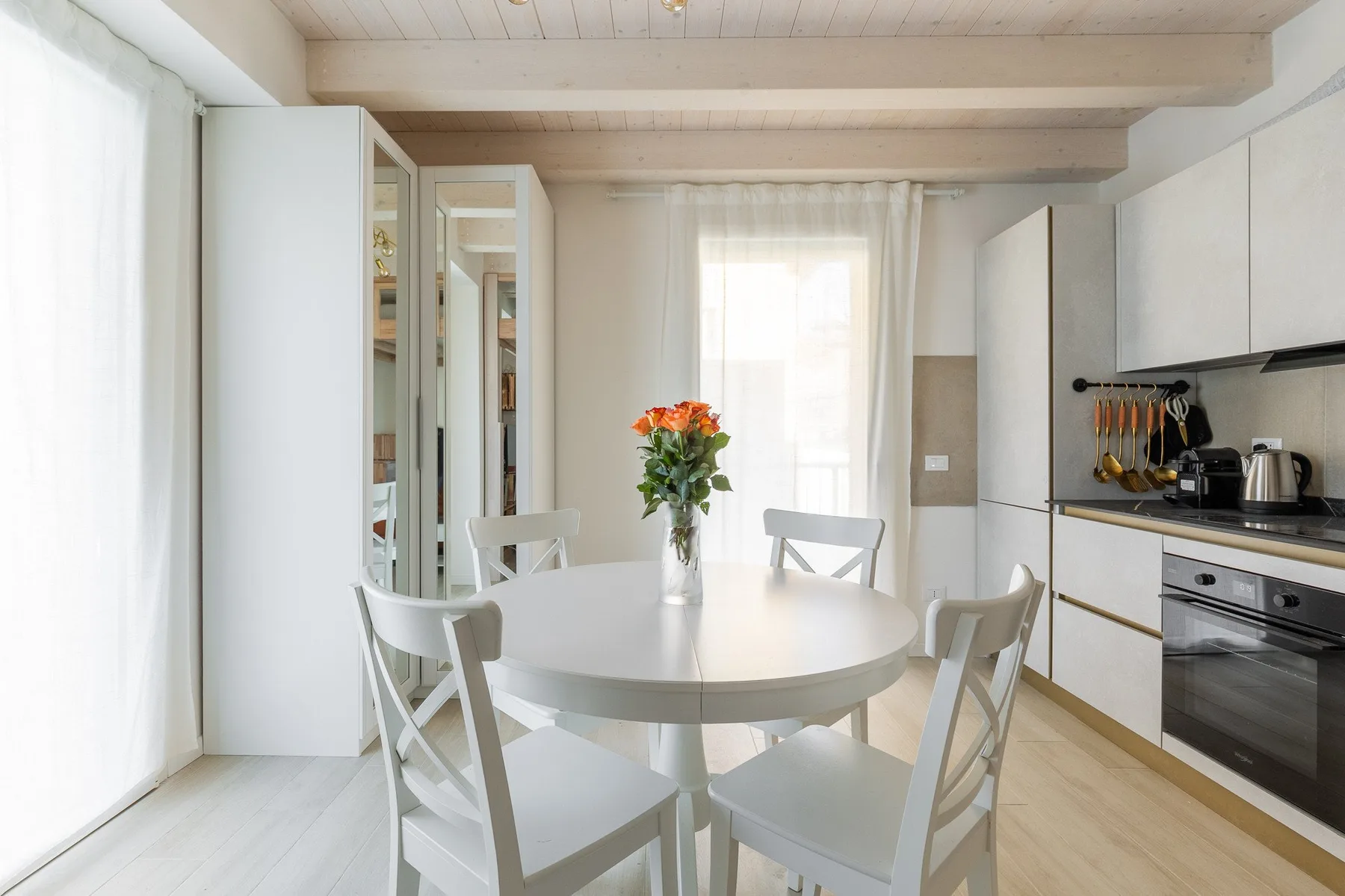 Un comedor luminoso con una mesa redonda junto a una cocina moderna.