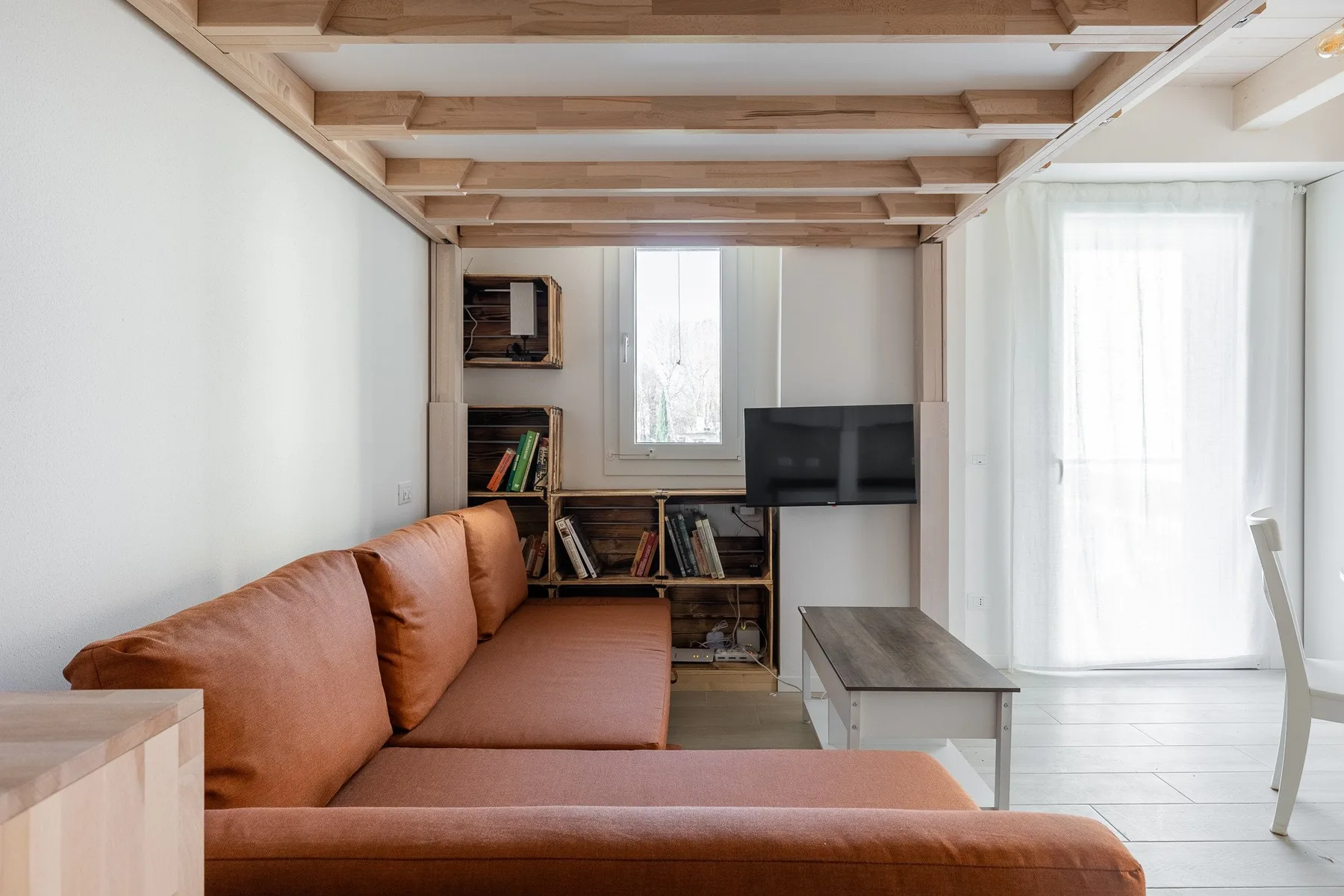 Una sala de estar con asientos, una mesa de centro y un televisor.