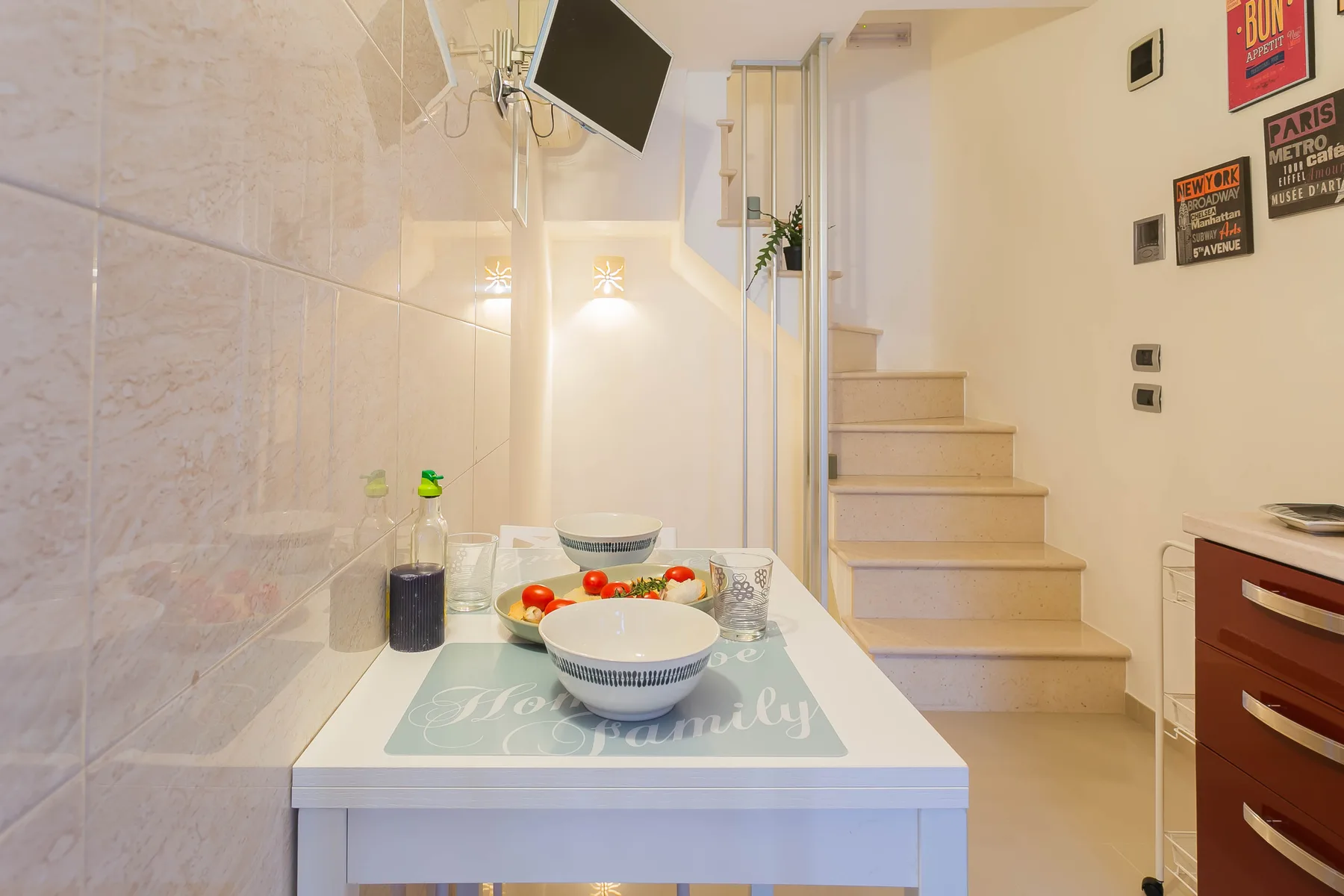 A bright dining area with a small table beside a staircase.