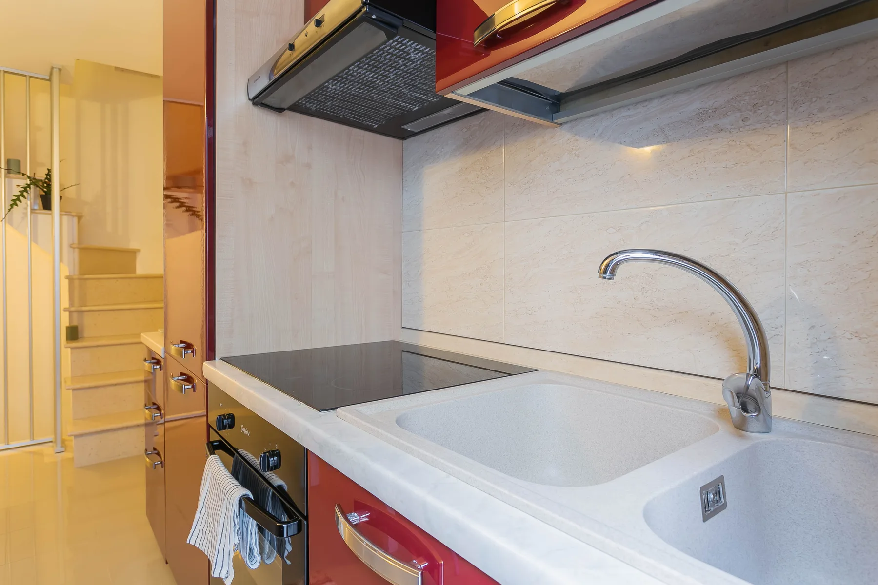 A kitchen counter with a sink, cooktop, and built-in oven.