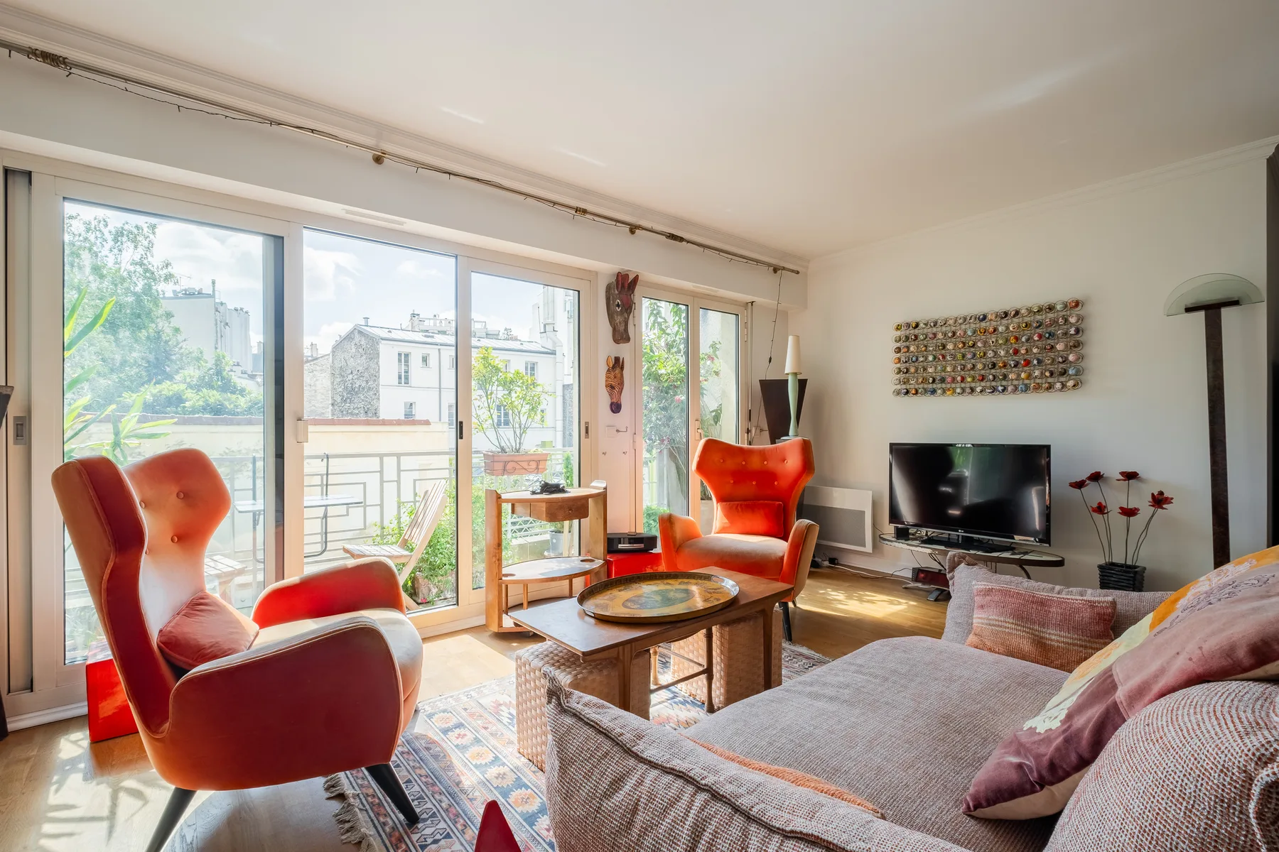 A bright living room with seating around a coffee table beside large windows.