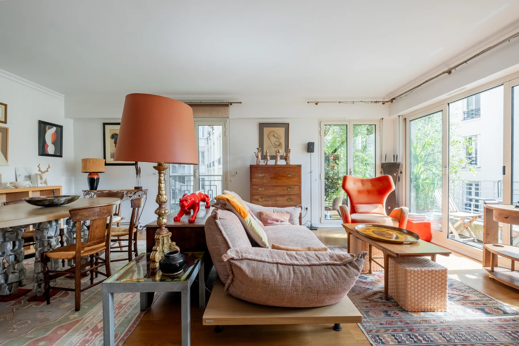 A bright living room with seating, a coffee table, and large windows.