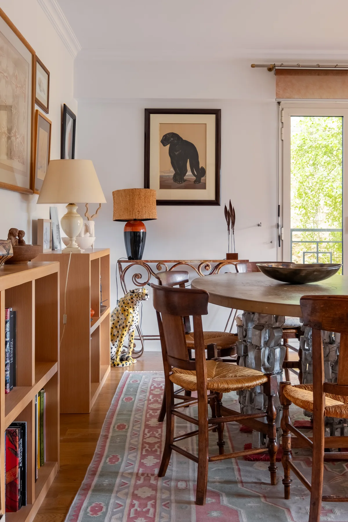 Un comedor con una mesa de madera, sillas y cuadros en la pared.