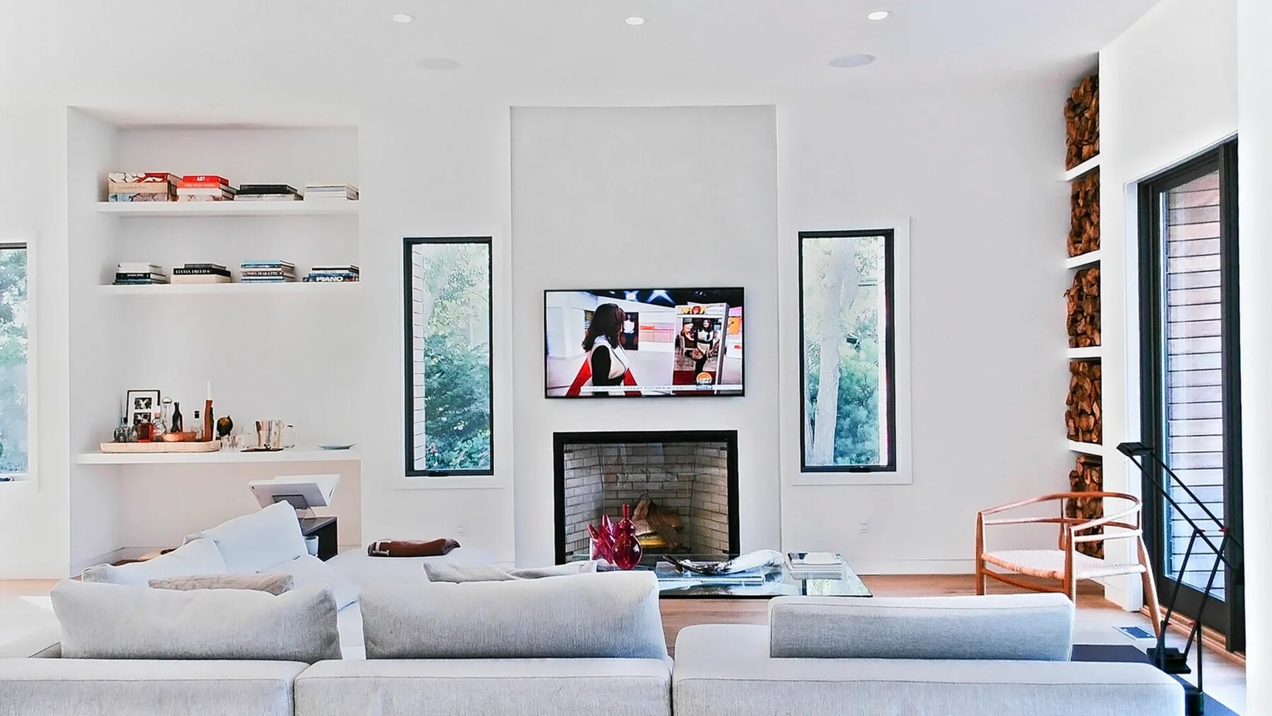 Una sala luminosa con asientos, un televisor y una chimenea.