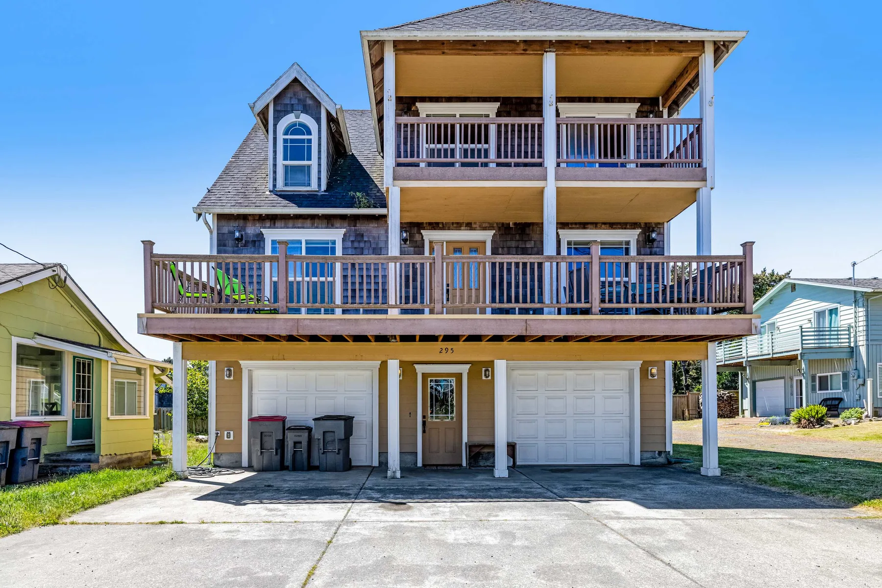 A multi-level house with broad wooden balconies and a garage below.