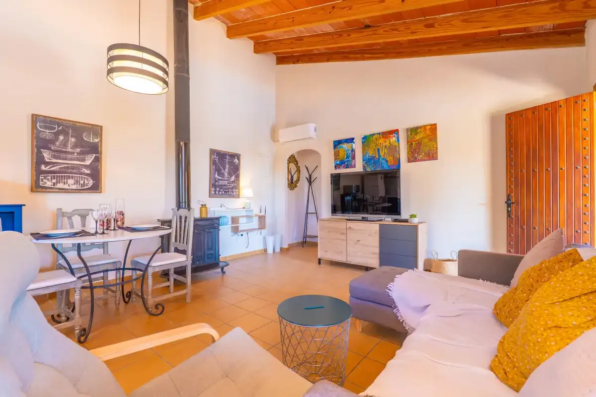 Una sala de estar con asientos, un televisor y una mesa de comedor.
