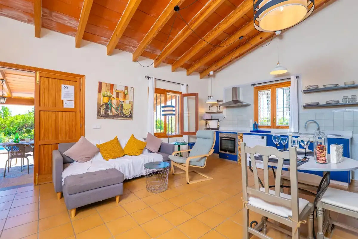 Sala de estar y cocina de planta abierta con asientos y una mesa de comedor.