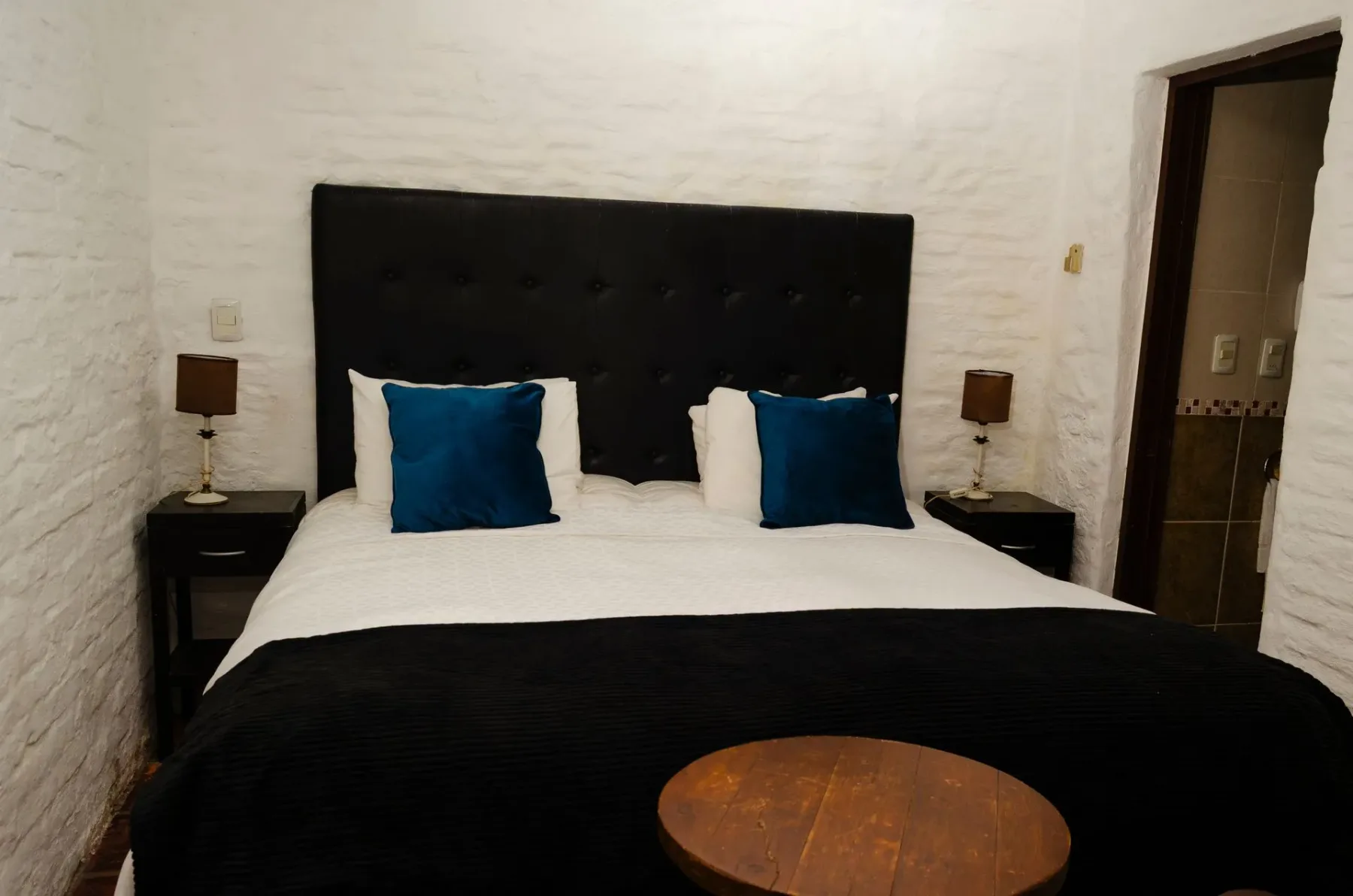 Habitación de hotel con una cama queen size y lámparas de noche.