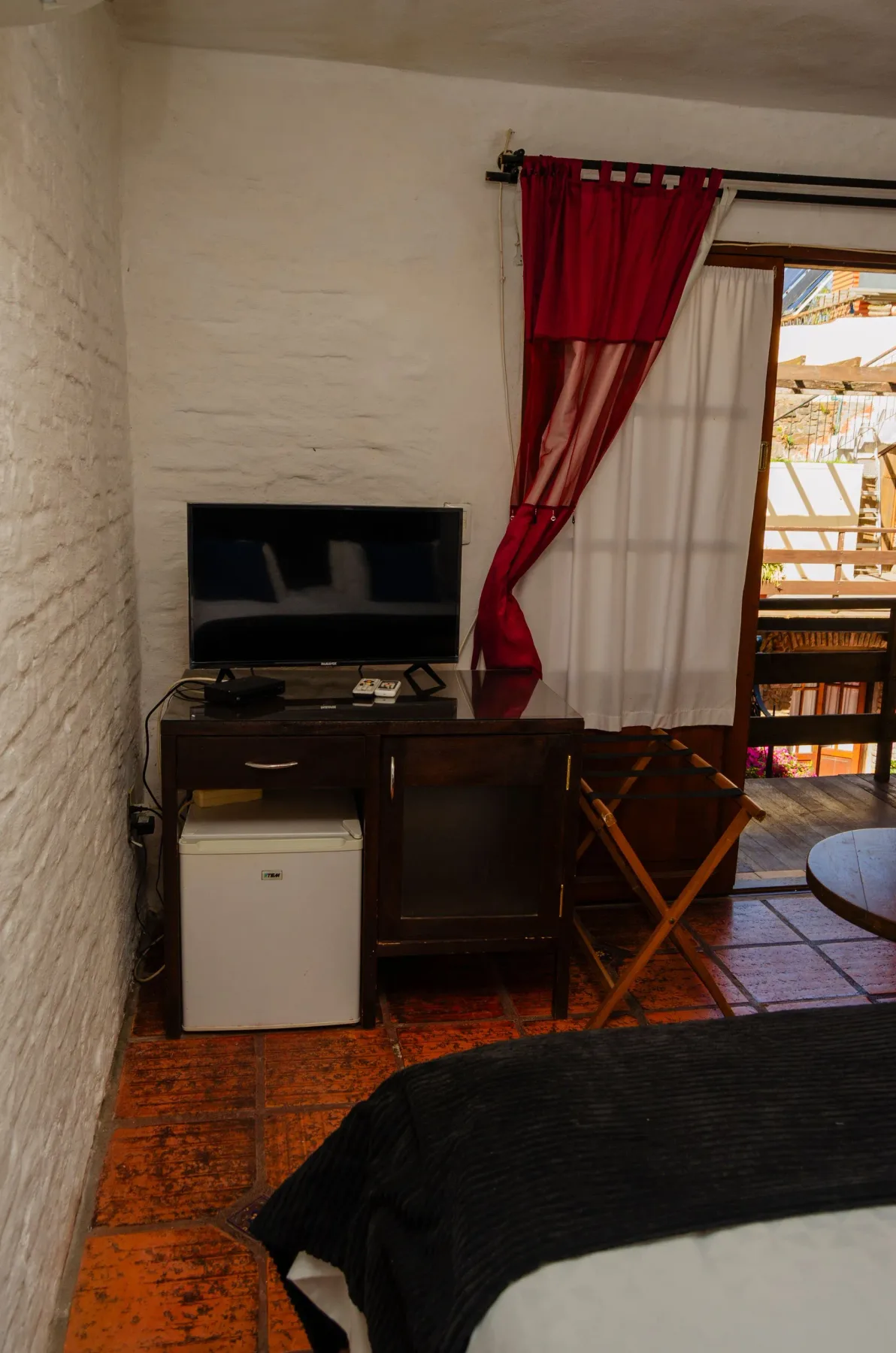 Televisor y minibar en una habitación.