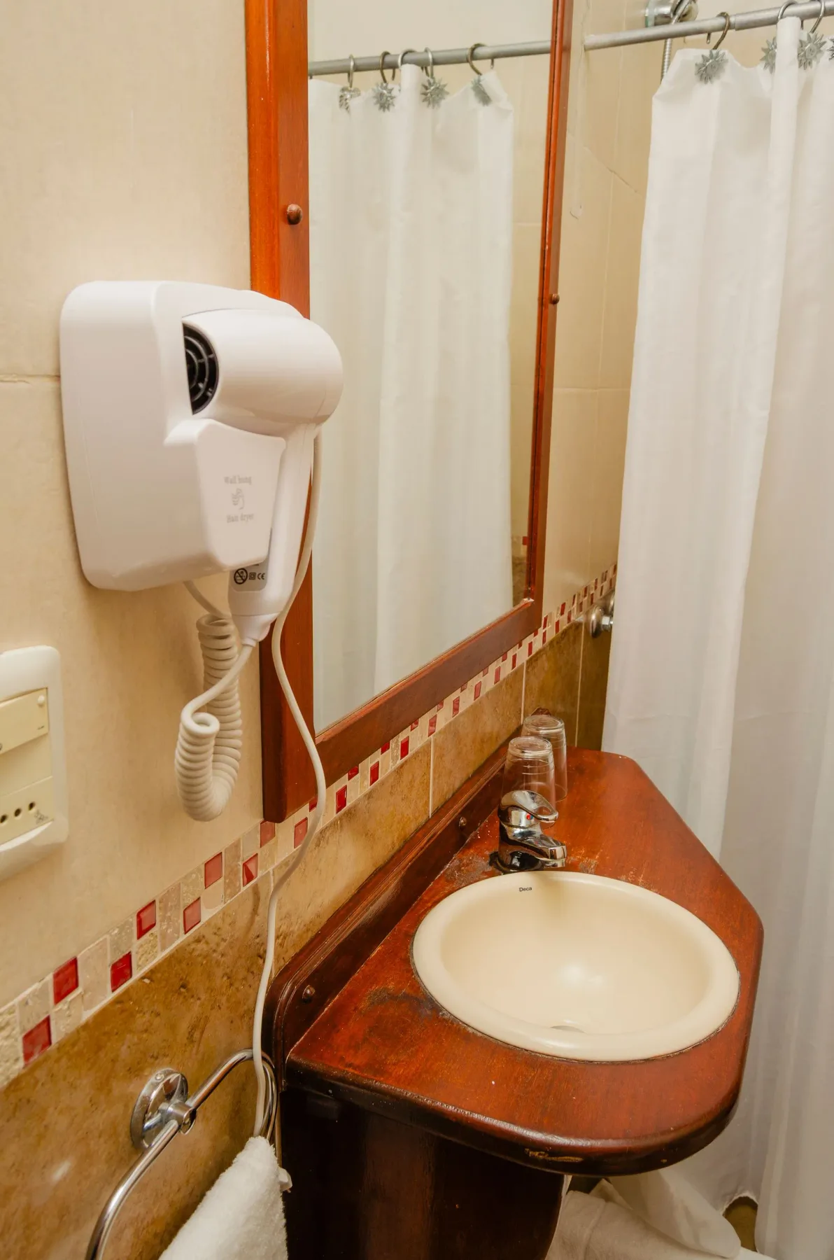 Mueble de lavabo con un secador de pelo montado en la pared.