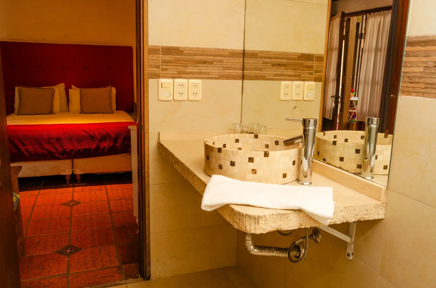 Lavabo de piedra con vistas a un dormitorio contiguo.