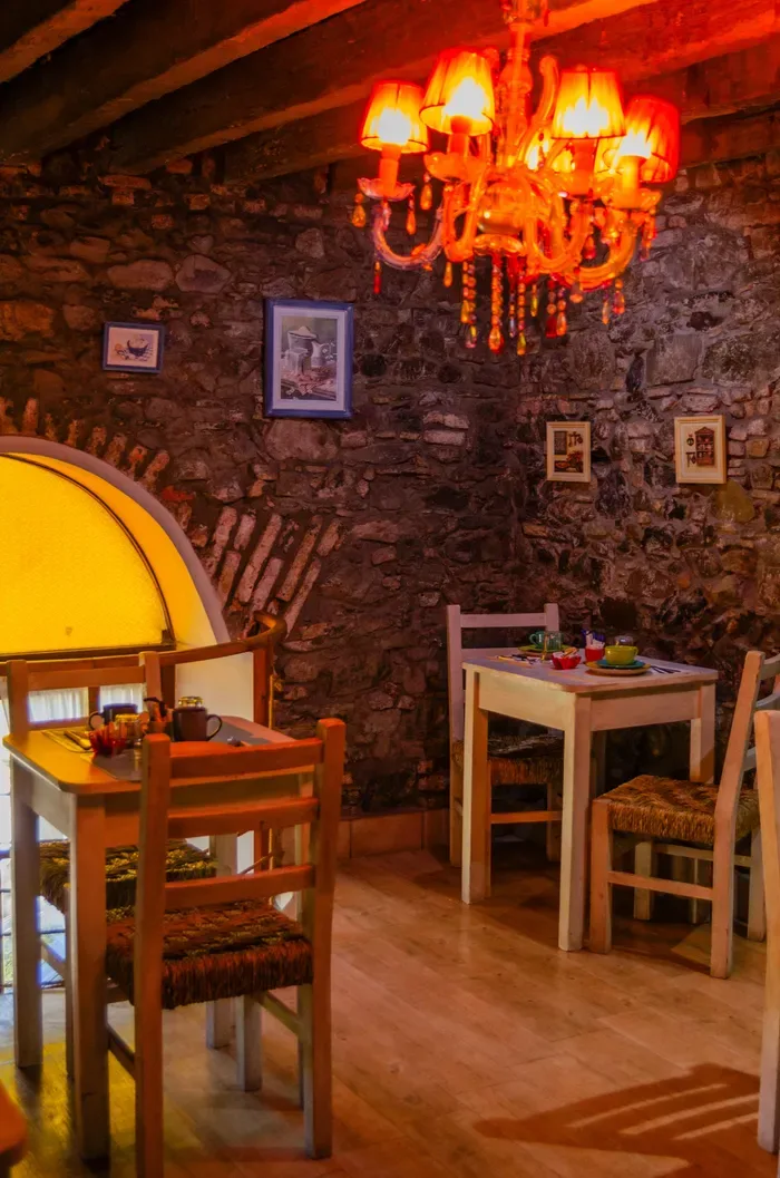 Comedor con paredes de piedra y mesas.