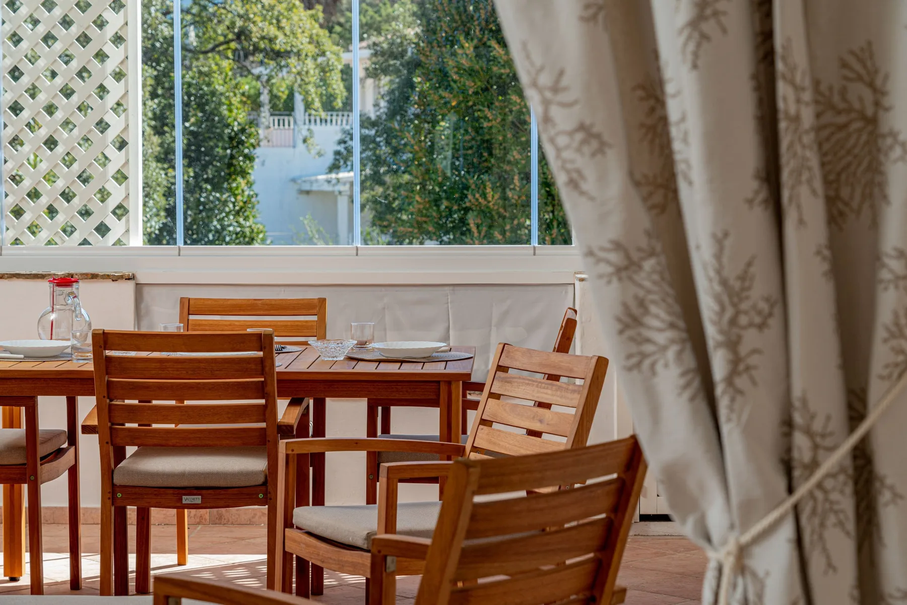 A dining area with wooden seating beside a large window.