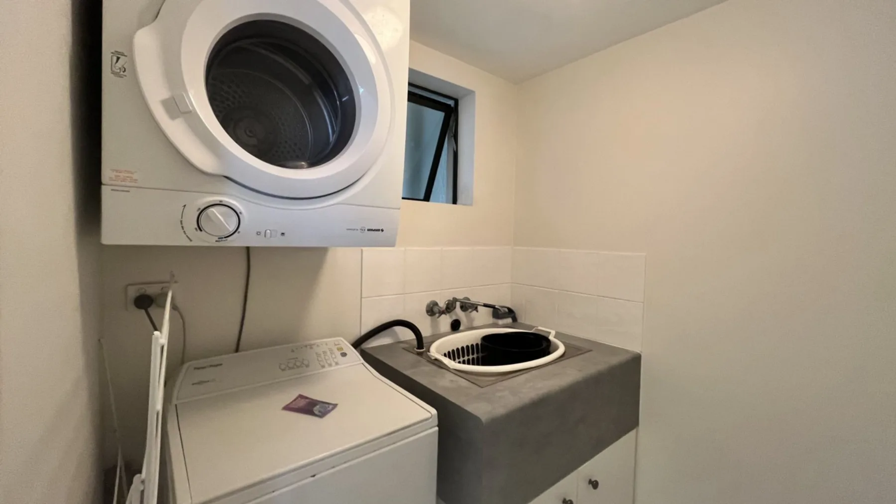A laundry area with a washing machine, dryer, and utility sink.