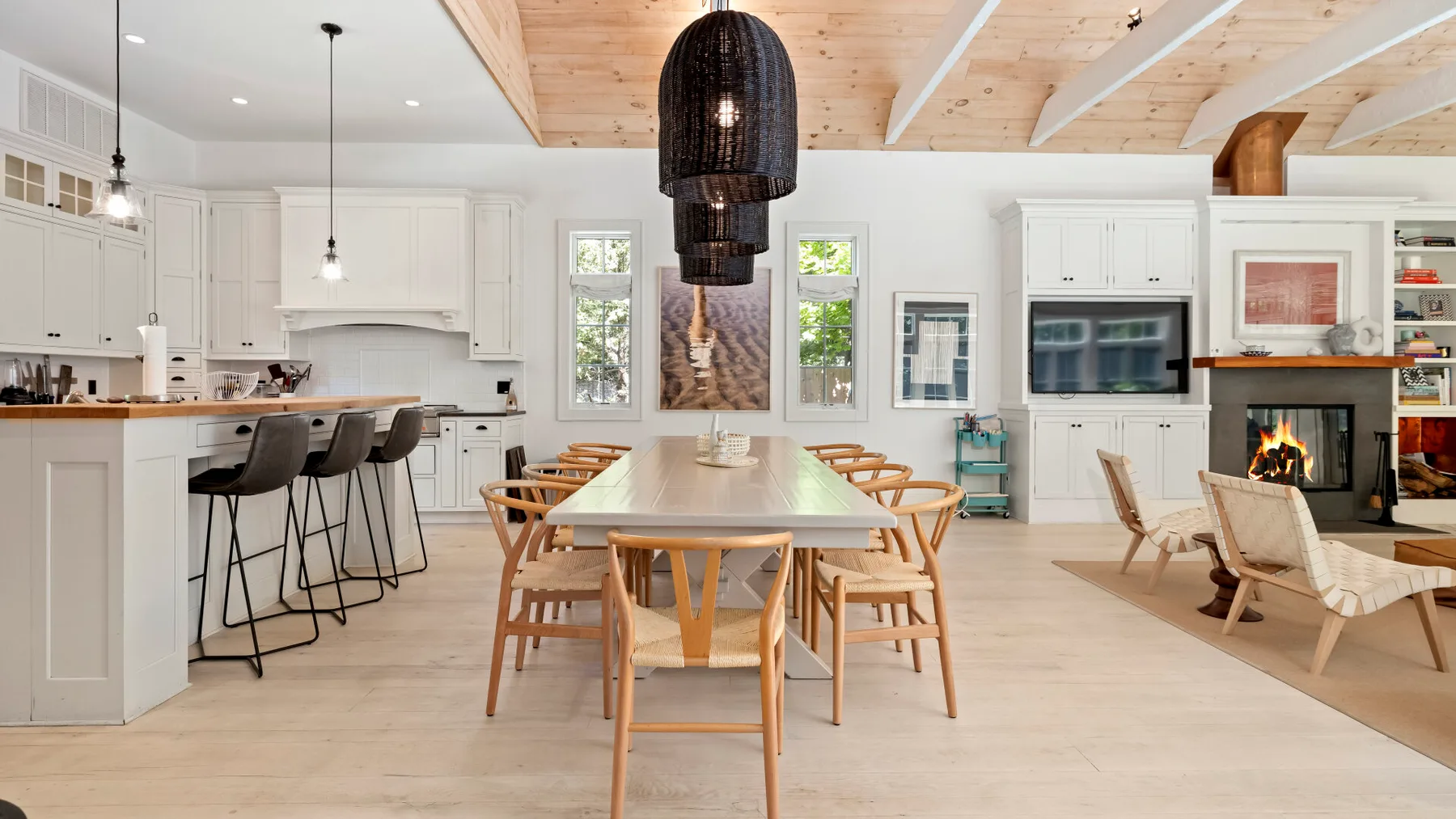 Una cocina abierta y zona de comedor con una mesa larga de madera y una chimenea.