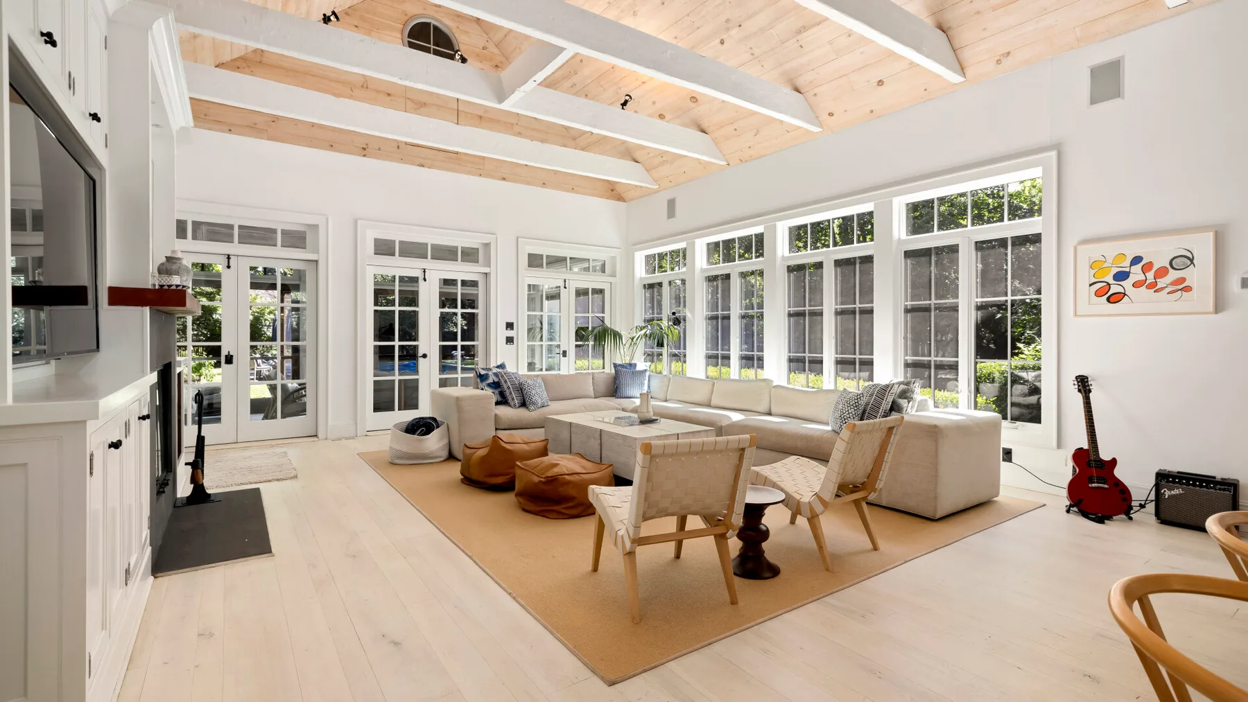 Una sala luminosa con asientos alrededor de una mesa de centro y grandes ventanas.