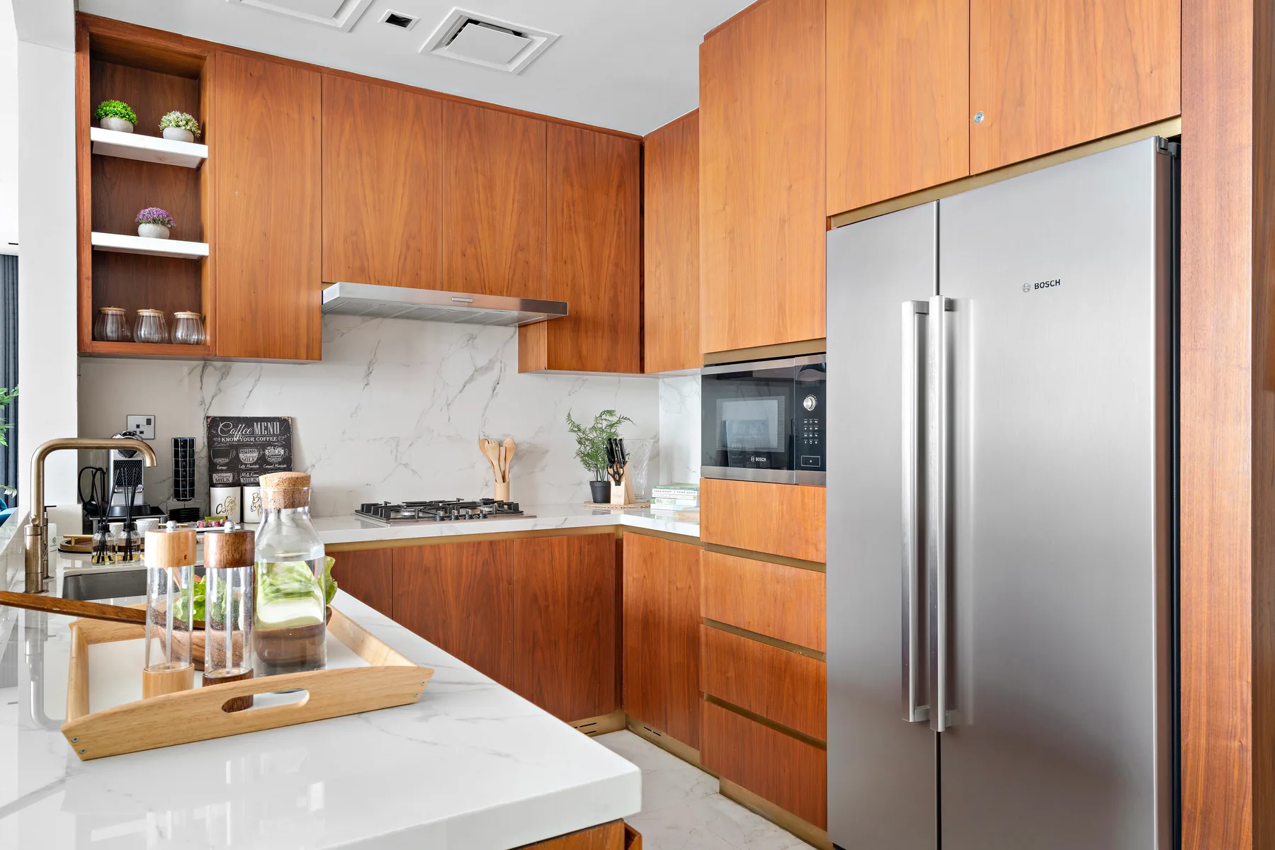 A modern kitchen with wooden cabinets, a countertop, and stainless steel appliances.