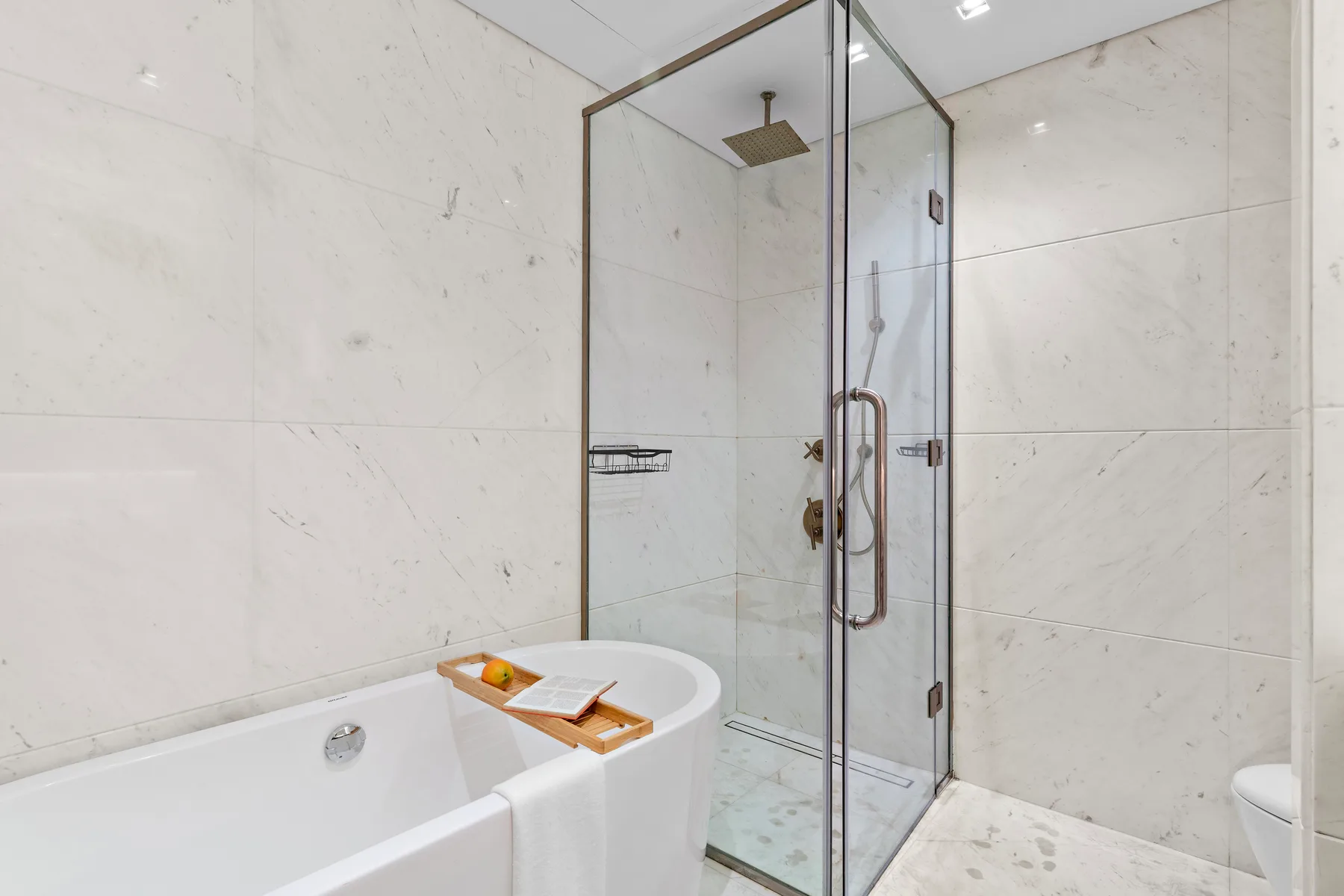 A bright bathroom with a freestanding tub beside a glass shower.