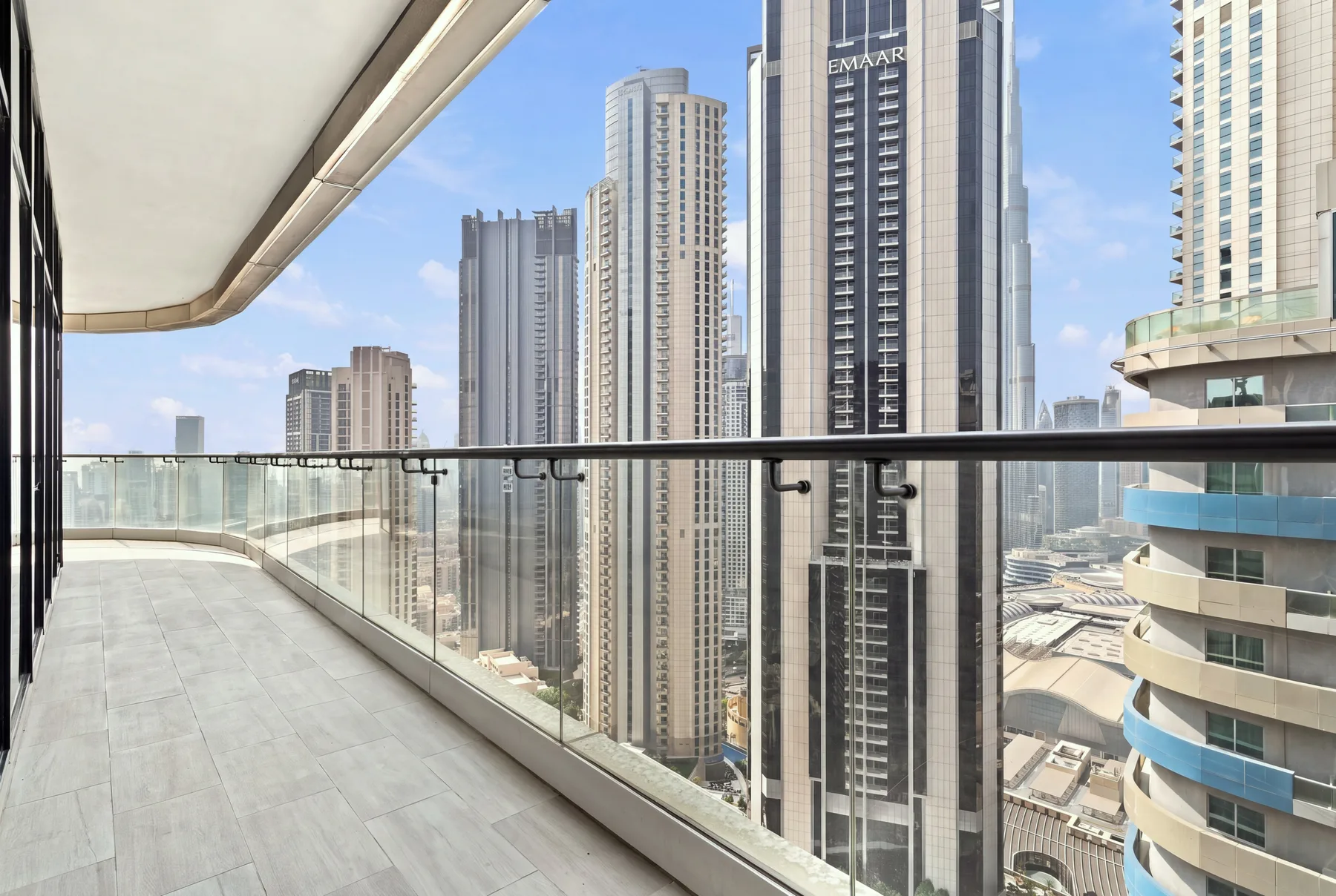 A spacious balcony overlooks a cluster of tall city buildings.