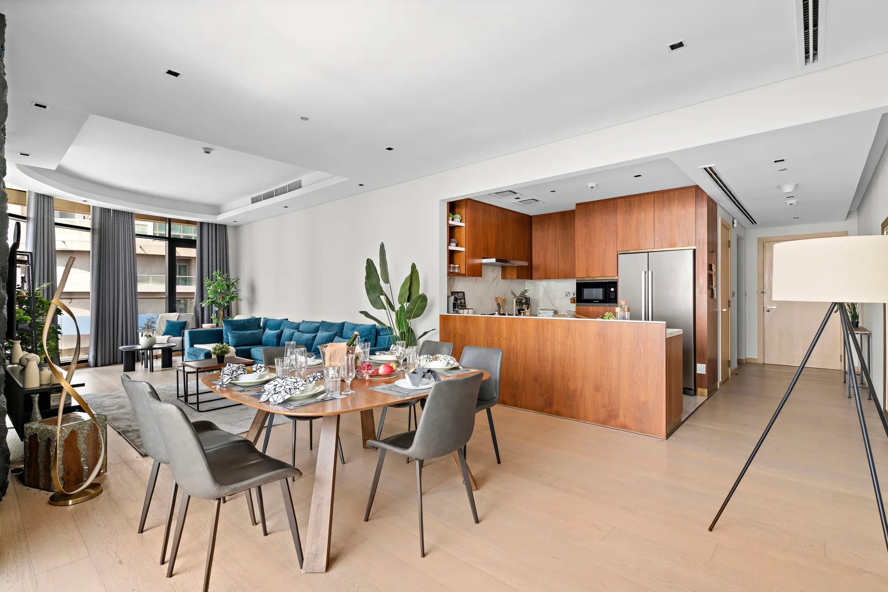 An open-plan dining and kitchen area has a set table and wood cabinetry.