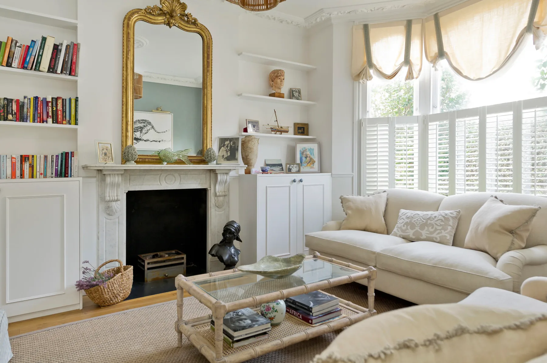 A bright living room with a fireplace, bookshelves, and seating.