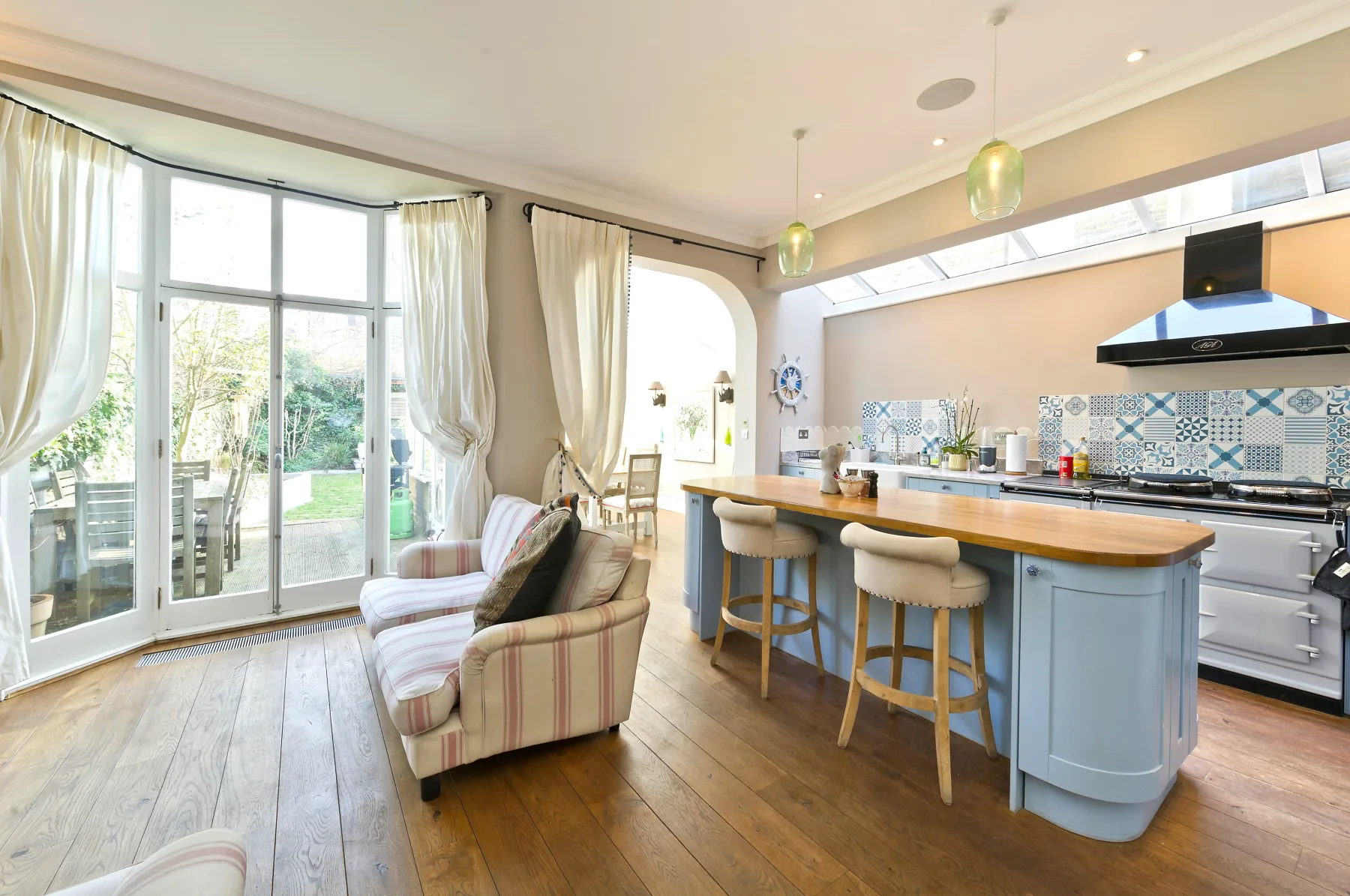 An open-plan living and kitchen area has a breakfast bar and sliding glass doors.