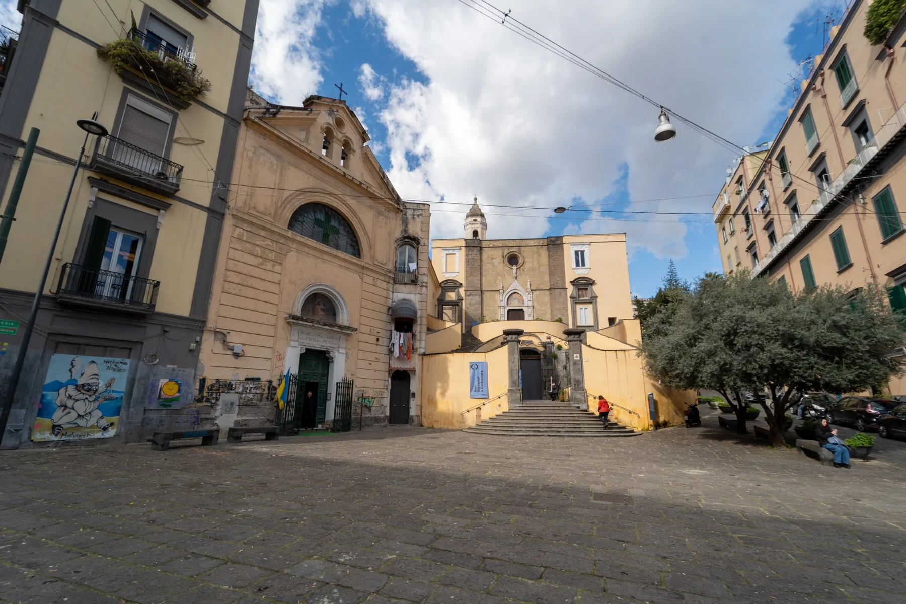 Una plaza pavimentada con edificios históricos y la fachada de una iglesia.