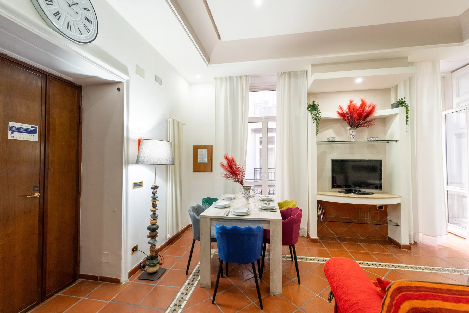 Un comedor con una mesa y sillas junto a un televisor.