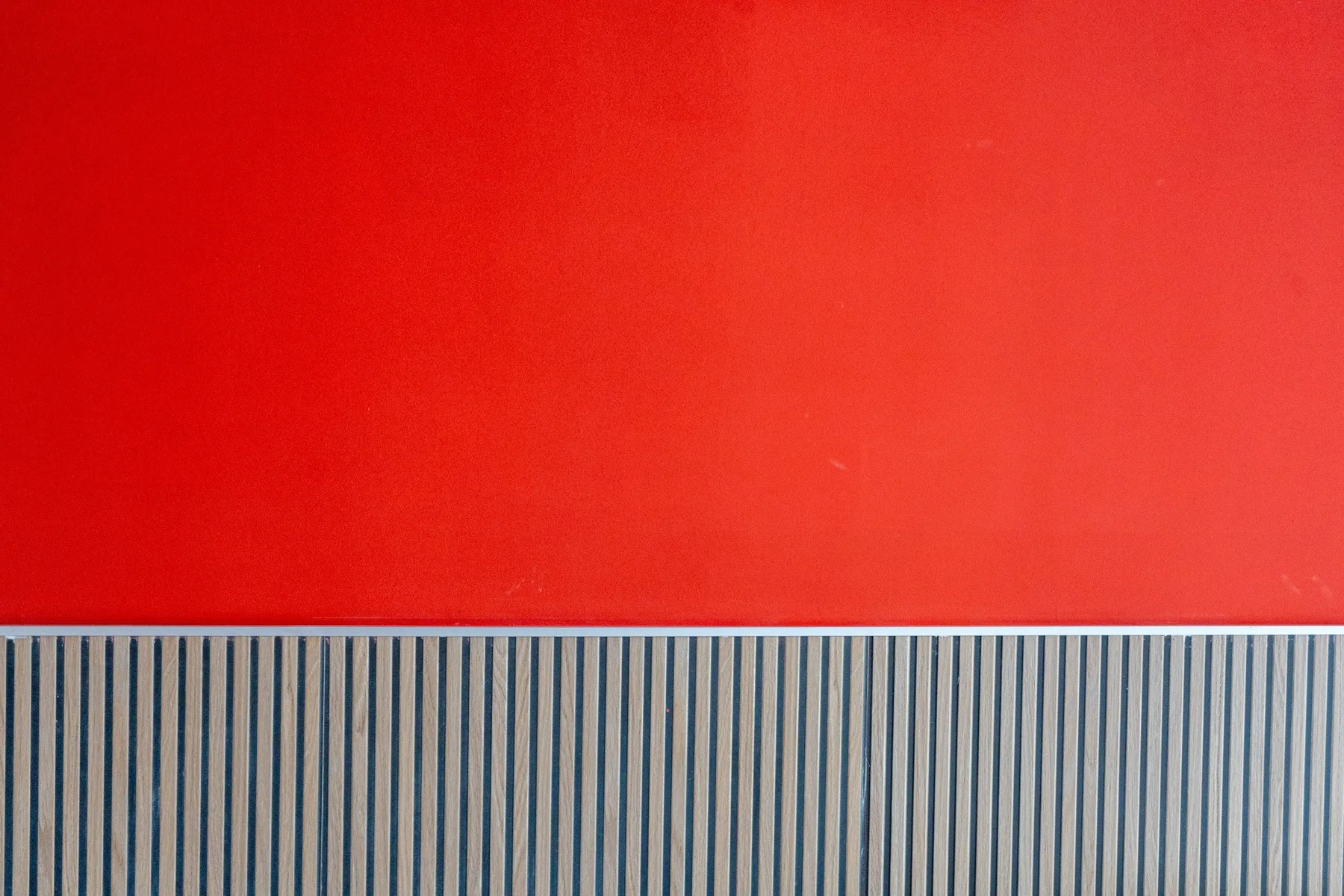 Una pared con una sección superior roja y un panel inferior a rayas.