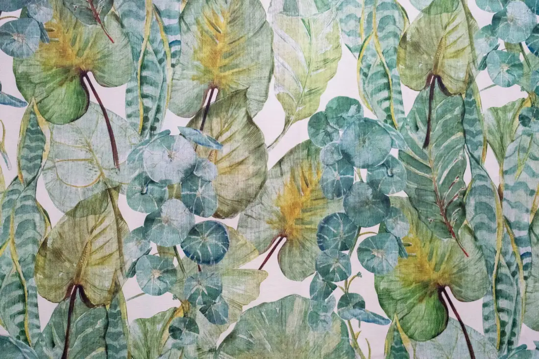 Un primer plano de papel tapiz botánico con hojas en tonos verdes y azules.