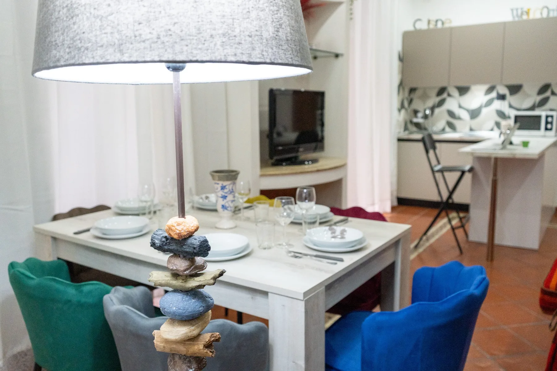 Un comedor con la mesa puesta está junto a una cocina compacta.