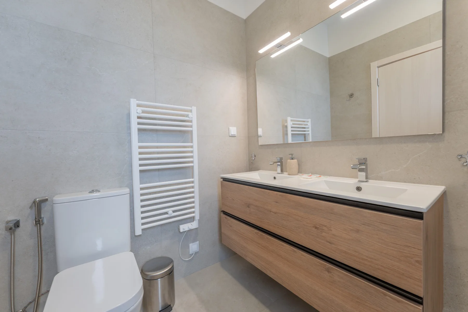 A bathroom with a wide vanity and a large mirror.