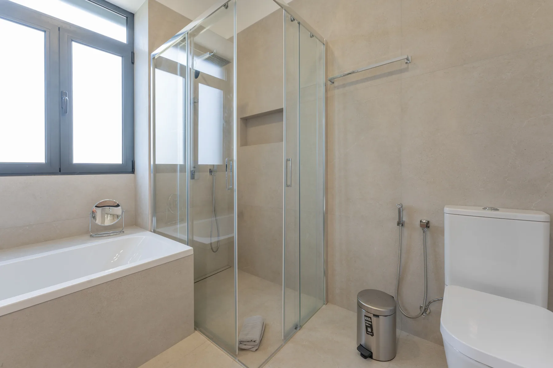 Un baño con bañera, ducha de cristal e inodoro.