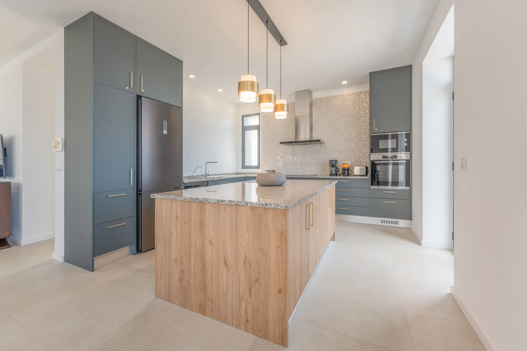 Una cocina moderna con una isla de frente de madera y electrodomésticos empotrados.