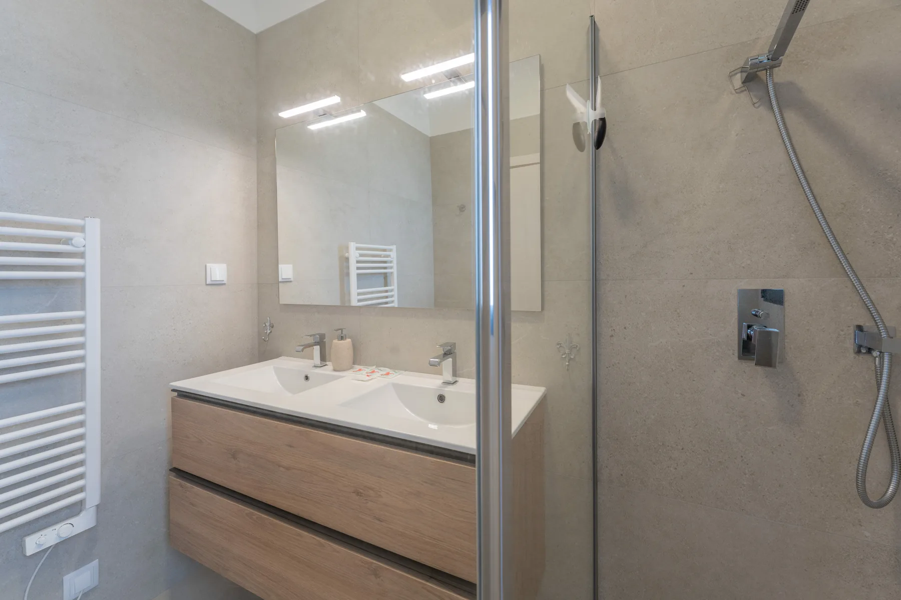 Un baño con lavabo, espejo y ducha de vidrio.